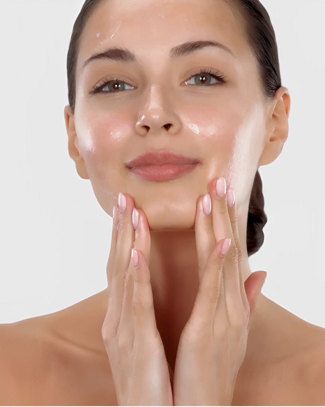 Woman with clear skin gently touching her cheeks and chin with both hands